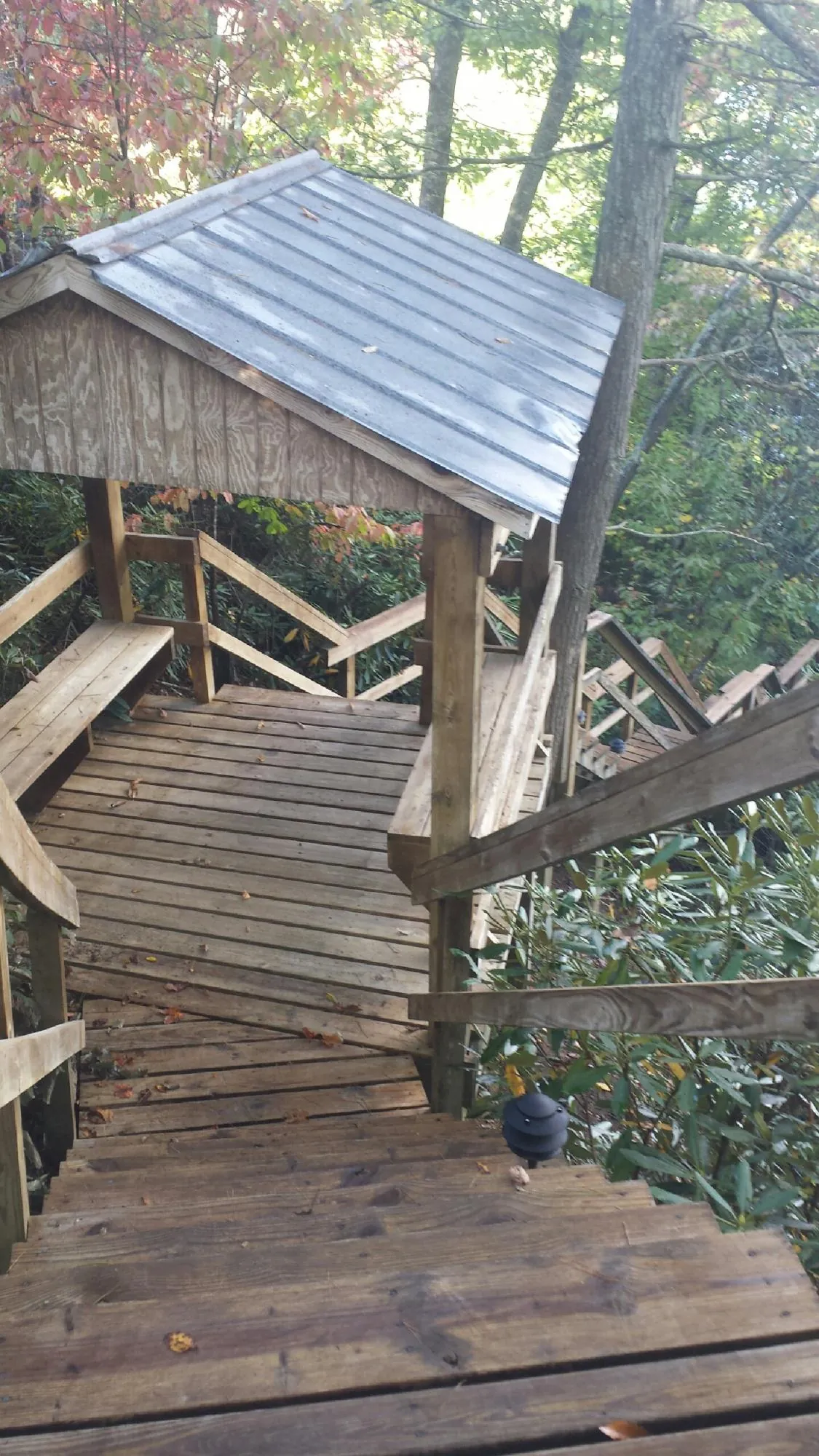 Metal roofed shelter over wooden steps on a wooded walkway — Skylight Repair & Installation work by our crew in Hamden